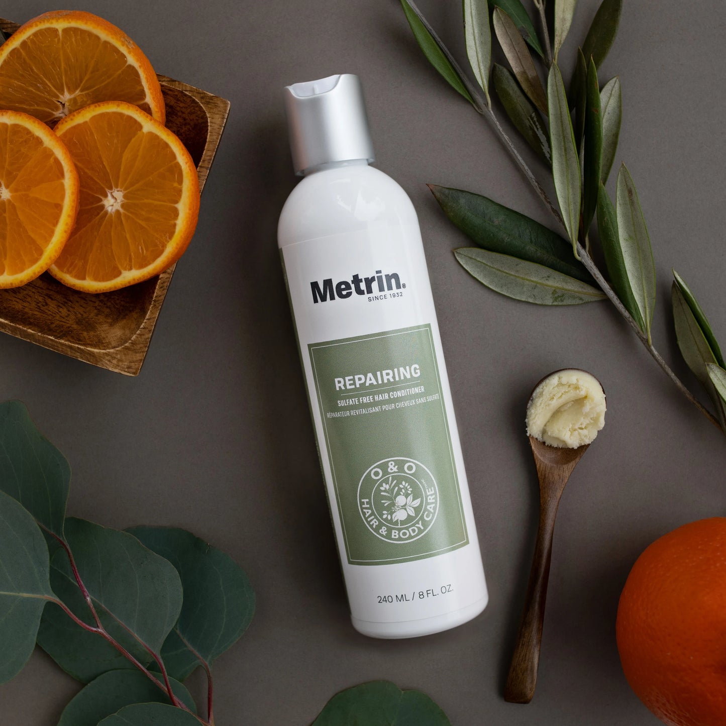 Metrin repairing conditioner bottle with oranges and leaves on a brown background