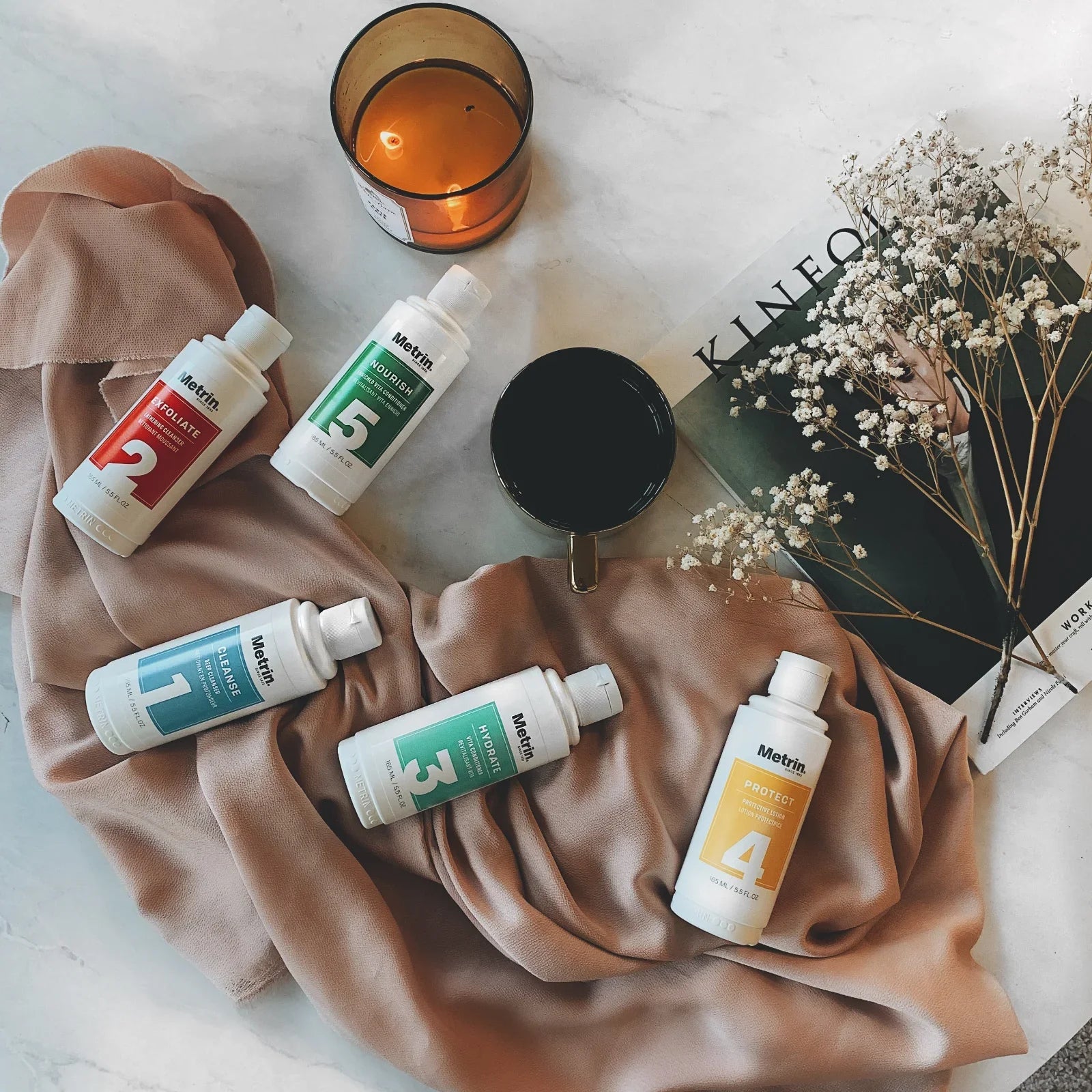 Metrin individual skincare bottles from the 5-Step System shown in a flat-lay arrangement