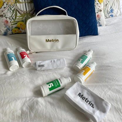 Metrin toiletry bag and bottles on a bed